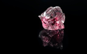Розовый драгоценный камень на черном фоне 
