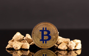 Монета биткоин с кусками золота на сером фоне