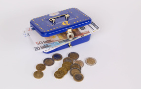 Blue piggy bank suitcase with money and coins on gray background