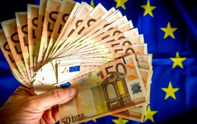 Bundle of euro in hand on the background of the flag