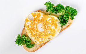 Кусок хлеба с яичницей и петрушкой