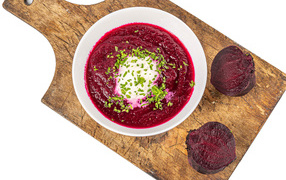 Свекольный суп в тарелке на белом фоне