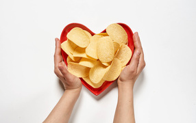 Чипсы в красной тарелке на белом фоне