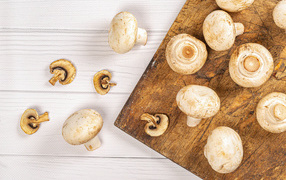 Свежие шампиньоны на разделочной доске