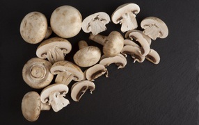 Свежие нарезанные шампиньоны на сером фоне