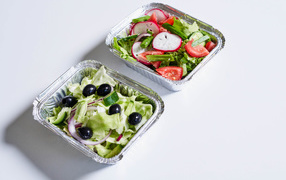 Салат из свежих овощей в тарелках на сером фоне 