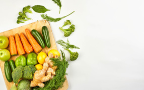 Свежие овощи на разделочной доске на белом фоне