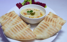 Хумус в белой тарелке с лавашом