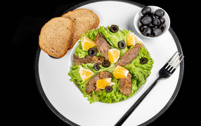 Листья салата с мясом на столе с хлебом