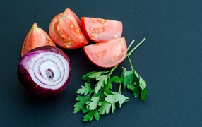 Лук, помидоры и петрушка на сером столе