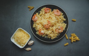 Макароны на тарелке с сыром и креветками