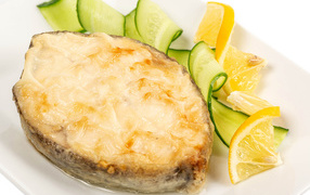 Картофель с сыром на тарелке с огурцами и лимоном 