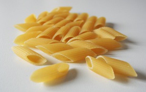 Сырые желтые макароны на сером фоне