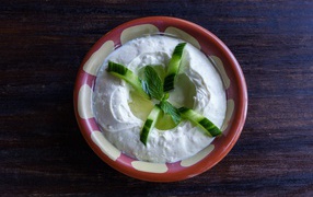 Соус с огурцами и листьями мяты в миске