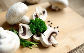 Sliced champignons with herbs on a board
