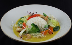 Вареный рис с овощами в большой белой тарелке