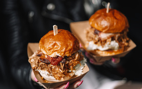 Два гамбургера в коробках в руках у девушки