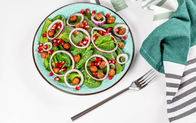 Вегетарианский салат с листьями базилика, орехами, зернами граната и луком