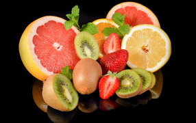 Цитрусовые фрукты с клубникой на черном фоне