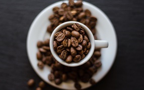 Кофейные зерна в белой чашке на столе 