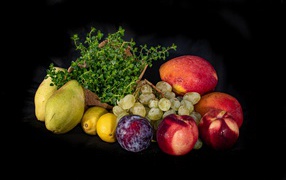 Свежие фрукты с зеленью на черном фоне 