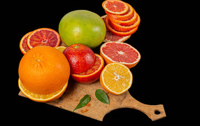 Свежие нарезанные цитрусовые фрукты на черном фоне