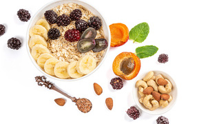 Oat flakes with berries and nuts on a white background