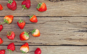 Спелая красная клубника лежит на деревянном столе