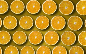 Круглые кусочки апельсина на желтом фоне