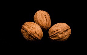 Три грецких ореха на черном фоне 