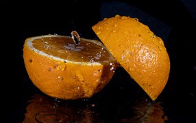 Две половины апельсина на черном фоне 