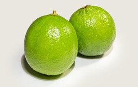 Два больших зеленых лайма на столе