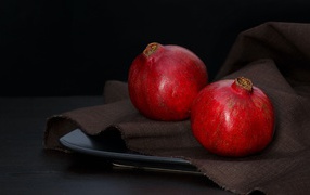 Два красных граната на столе