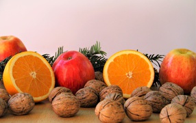 Грецкие орехи с апельсинами и яблоками на столе