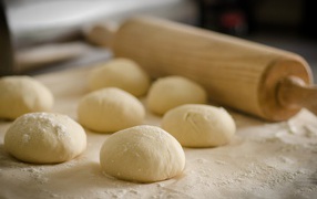 Bun dough and rolling pin on the table
