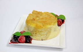 Пирожное на большой белой тарелке с ягодами