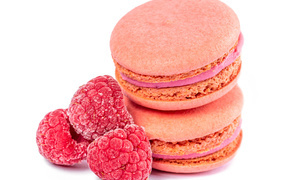 Десерт макарон с малиной на белом фоне