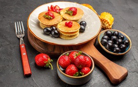 Оладьи с виноградом и клубникой на тарелке 