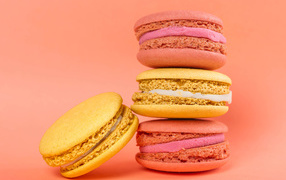 Разноцветный десерт макарон на розовом фоне