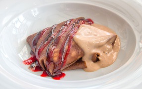 Блинчик с джемом и йогуртом в белой тарелке