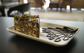 Кусок торта с фисташками на белой тарелке 