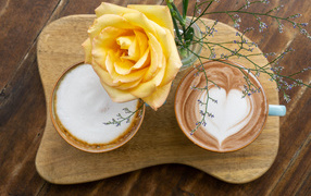 Красивая оранжевая роза на столе с кофе