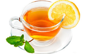 Чашка чая с лимоном и мятой на белом фоне
