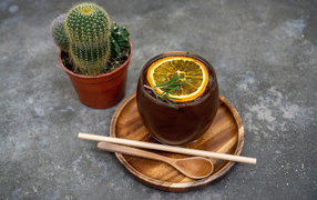 Чай с лимоном на столе с колючим кактусом