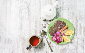 Чай на тарелке с кусочками лимона на столе