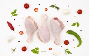 Fresh chicken thighs with peppers and tomatoes on a white background