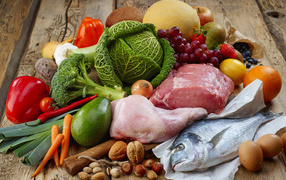 Мясо с рыбой на столе с овощами и фруктами 