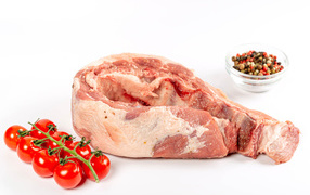 Кусок мяса на белом фоне с помидорами и специями 