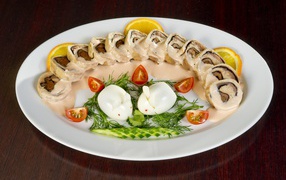 Рулет на тарелке с овощами и яйцом