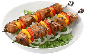 Шашлык с болгарским перцем на тарелке с листьями салата